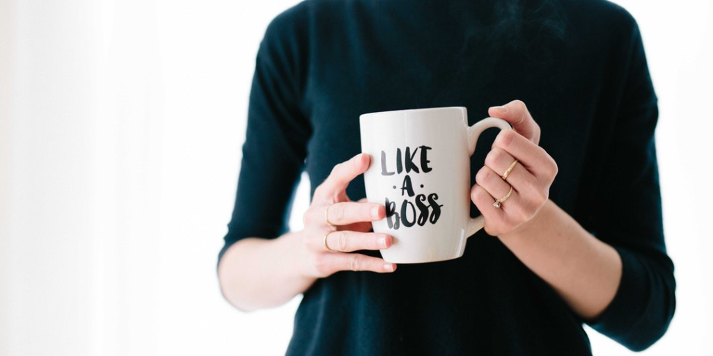 woman holding coffee cup that says like a boss