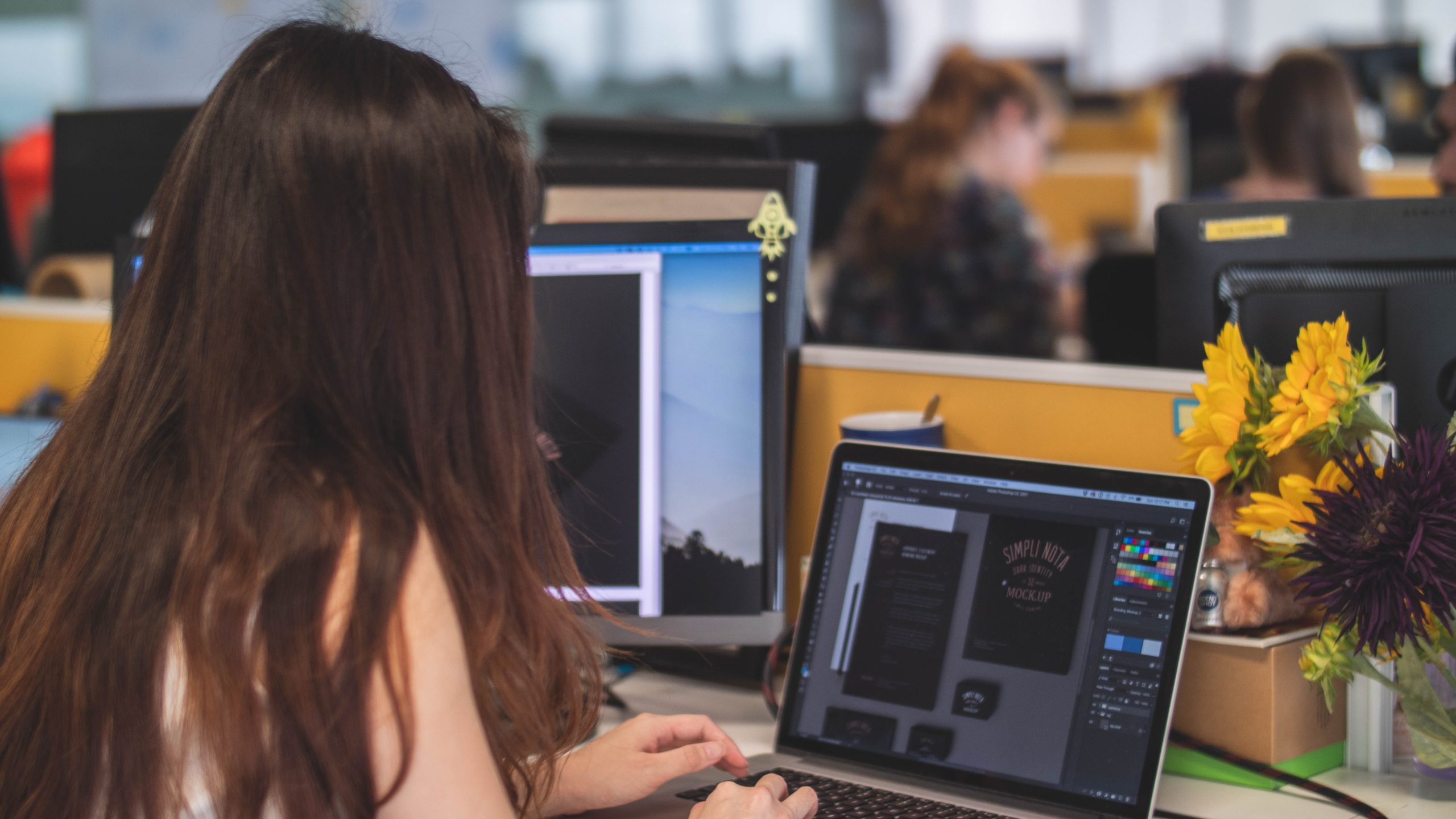 girl using illustrator on laptop in workplace