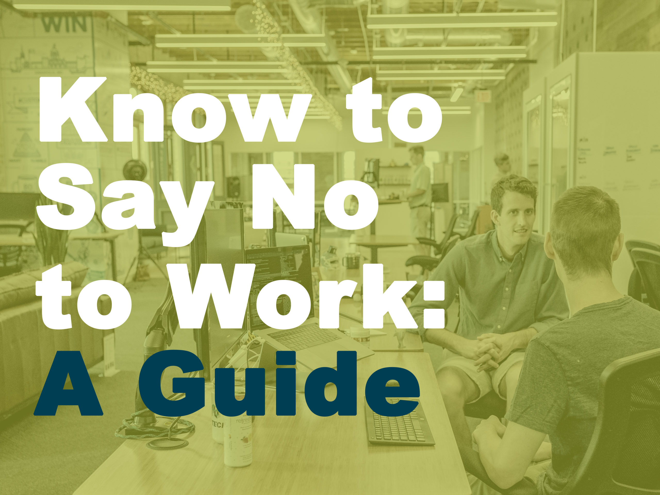 men in workplace in front of desktops talking